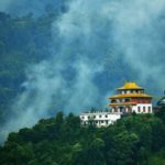 Monastery in Sikkim surrounded by lush greenery and fog